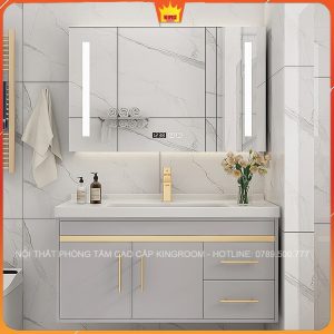 Tủ lavabo Inox 304 NA7 màu xám với chi tiết vàng, cùng gương đèn LED và hoa tươi, không gian phòng tắm sang trọng và ấm cúng