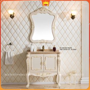 Phòng tắm cổ điển với tủ lavabo màu kem và gương viền hoa văn, tạo điểm nhấn sang trọng và thanh lịch
