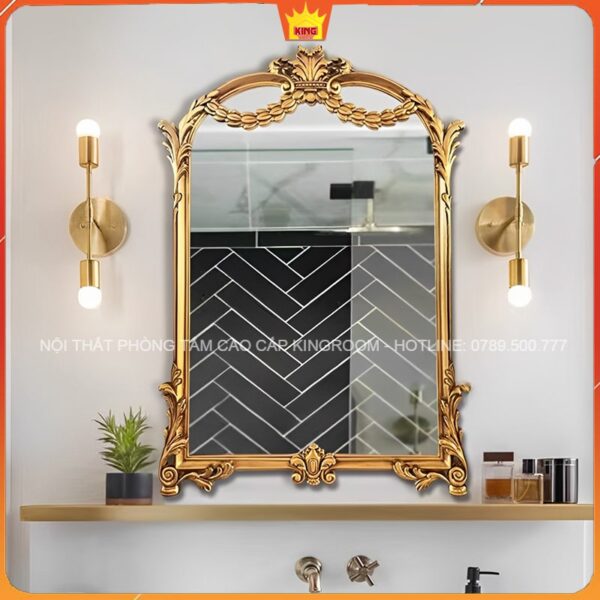 Gương vàng cổ điển treo trong phòng tắm hiện đại với đèn tường vàng và nội thất tối giản