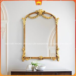 Gương cổ điển màu vàng đồng treo tường trên nền trắng, phản chiếu không gian yên tĩnh và thư giãn