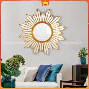 Gương mặt trời vàng treo phòng khách, bên cạnh sofa và đồ vật trang trí
