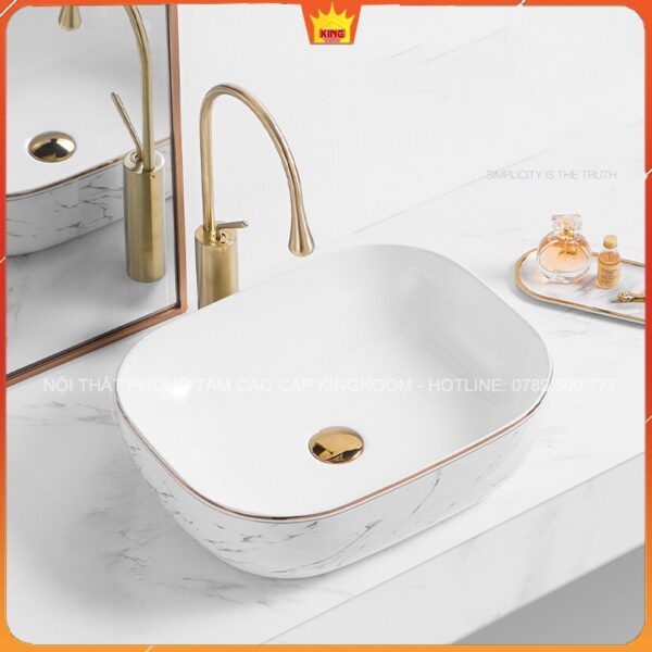 Lavabo Đặt Bàn Hình Chữ Nhật Aqua HH9 với thiết kế vòi nước màu vàng và họa tiết vân đá.
